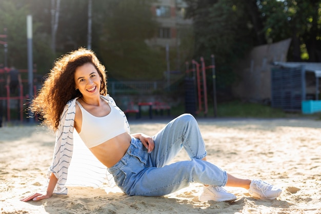 Foto gratuita giovane donna alla moda in posa sulla sabbia