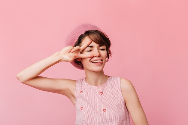 Fashionable young woman showing peace sign