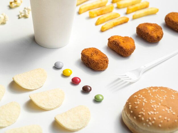 Fast food and candy on white table