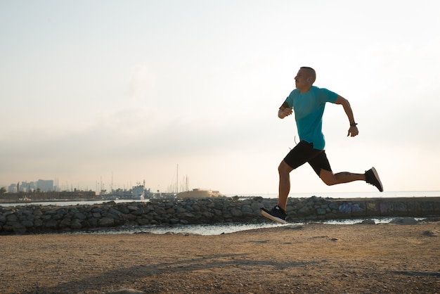 Free photo fast runner training alone on beach