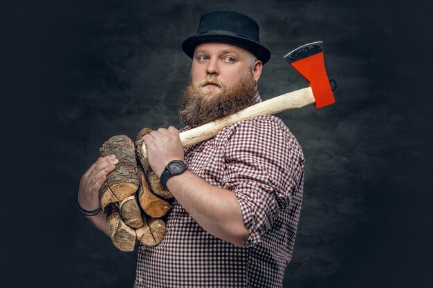 Толстый лысый бородатый мужчина держит топор и дрова.