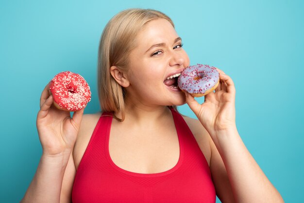 太った女の子はジムをやっていて サンドイッチを食べたいです 優柔不断と疑いの概念 プレミアム写真