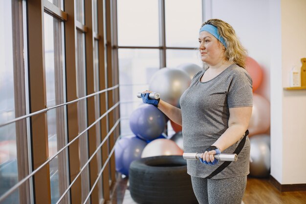 뚱뚱한 여자 다이어트, 피트니스. 체육관에서 운동하는 비만 여성의 초상화.