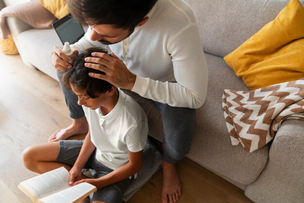 Father applying lice treatment high angle