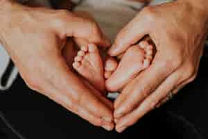 Free photo father and baby forming a heart shape