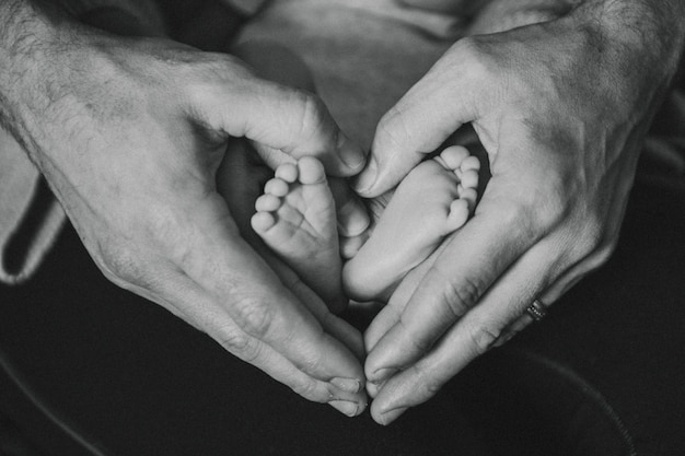 Free photo father and baby forming a heart shape