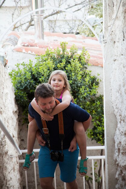 Father carrying his daughter on his back