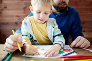 Free photo father and child coloring