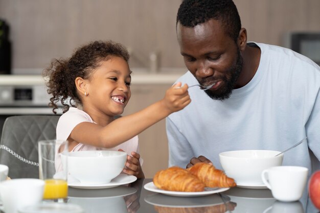 Father and daughter eating in the kitchen