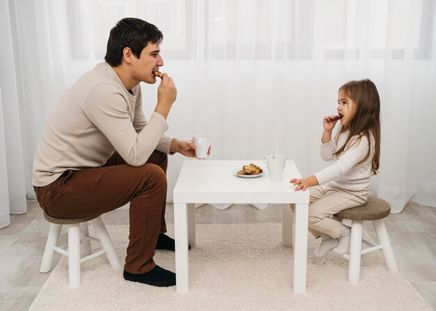 Father and daughter eating together at home