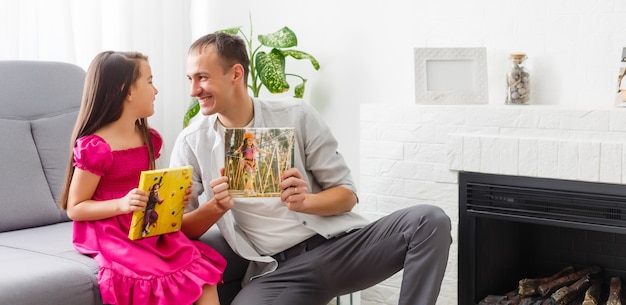 Father and daughter hold photo canvas in the interior