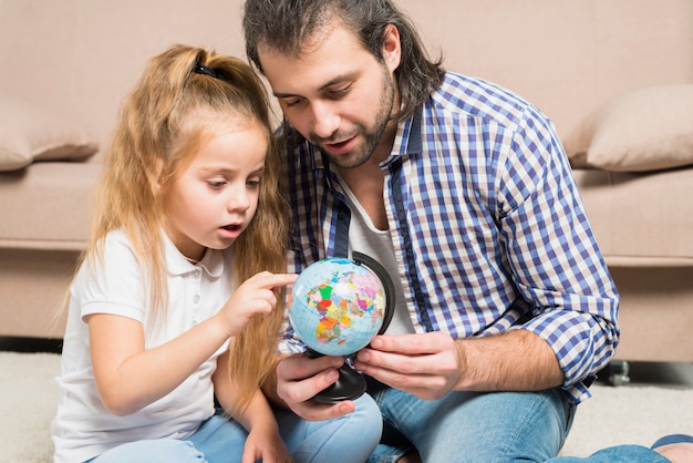 Отец и дочь, глядя на глобус
