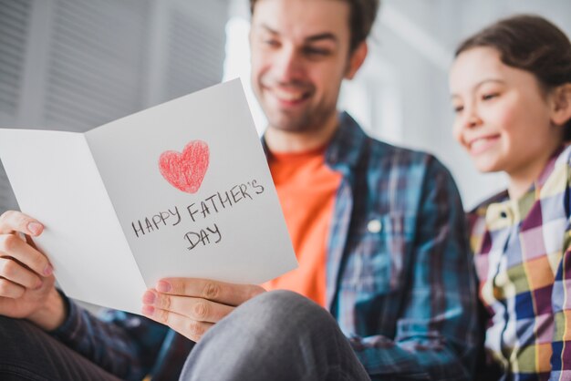 Father and daughter looking at hand drawn card on fathers day