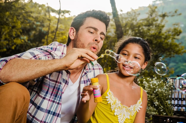 Father and daughter making soap bubbles