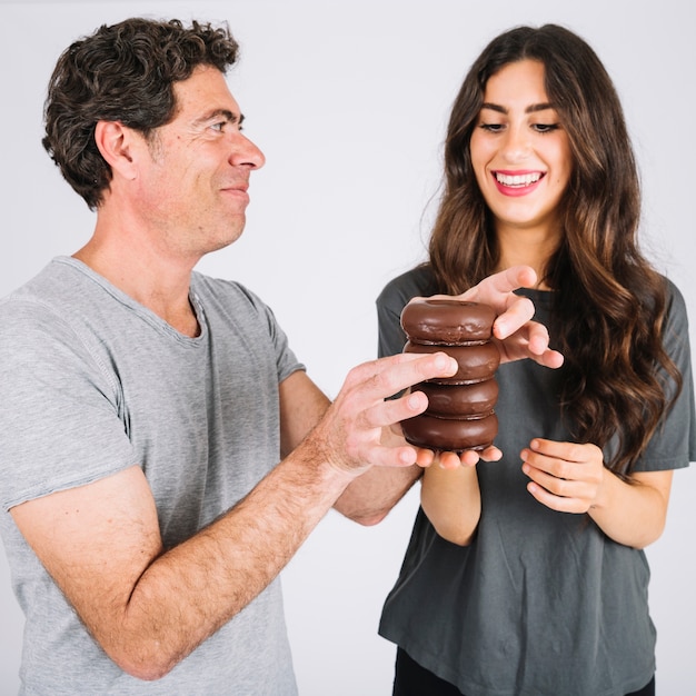 Father and daughter making tower from donuts