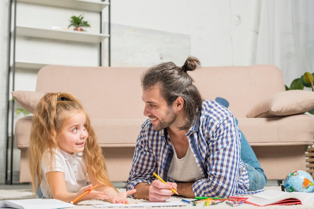 Free photo father and daughter painting on the floor