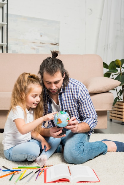 Father and daughter painting on the floor