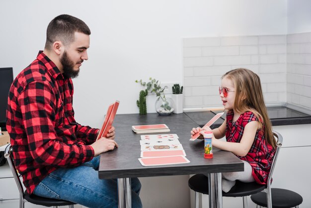Отец и дочь играют в карты в день отцов