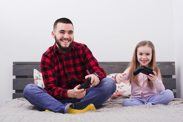 Father and daughter playing console