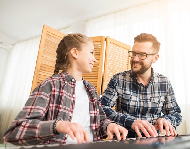 Father and daughter playing on the piano