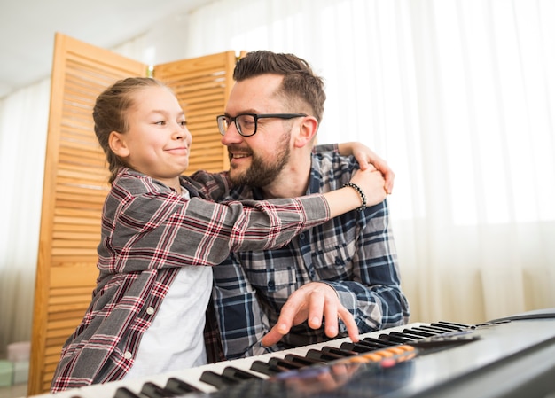Отец и дочь играют на пианино