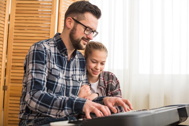 Father and daughter playing on the piano