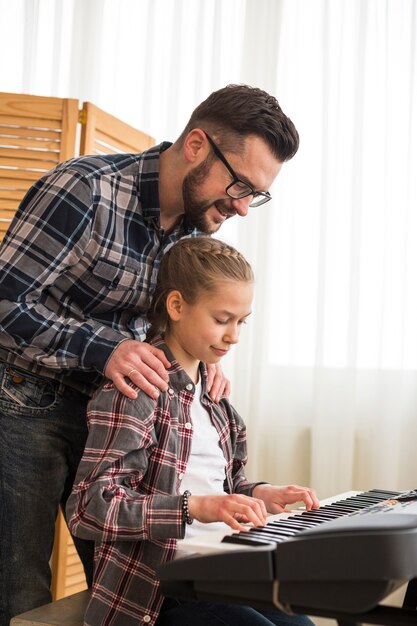 Father and daughter playing on the piano