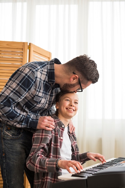 Foto gratuita padre e figlia che giocano al pianoforte