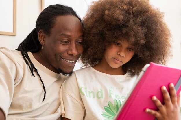 Отец и дочь играют вместе на планшете