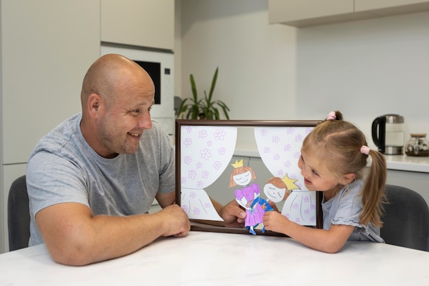 Father and daughter playing with puppets at home