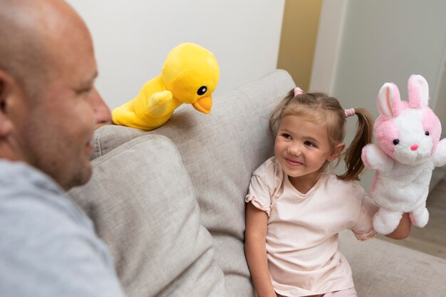 Father and daughter playing with puppets