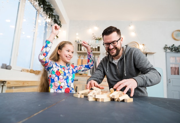 Free photo father and daughter playing with wood blocks