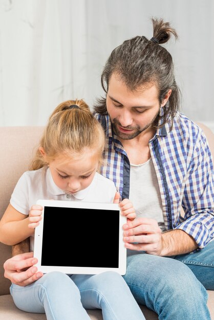 タブレットを見せる父と娘