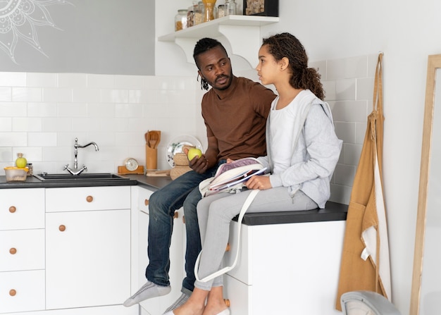 Father and daughter sitting on a kitchen counter