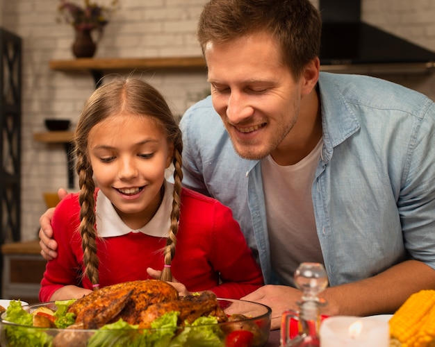 Father and daughter smelling the cooked turkey