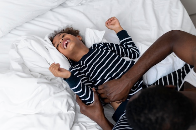 Free photo father and daughter tickling indoors