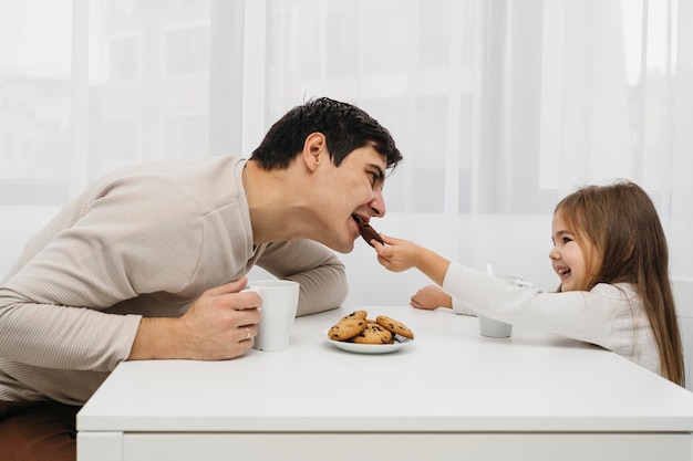 Father and daughter together at home eating