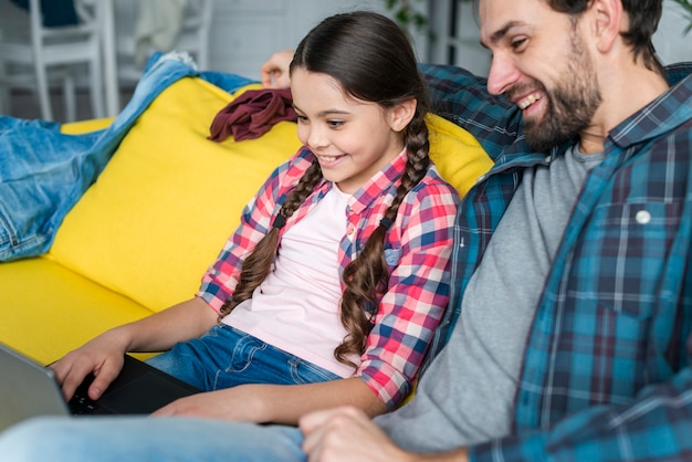 Free photo father and daughter using a laptop