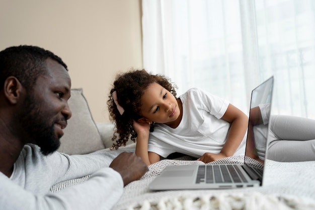 Free photo father and daughter watching a movie on a laptop