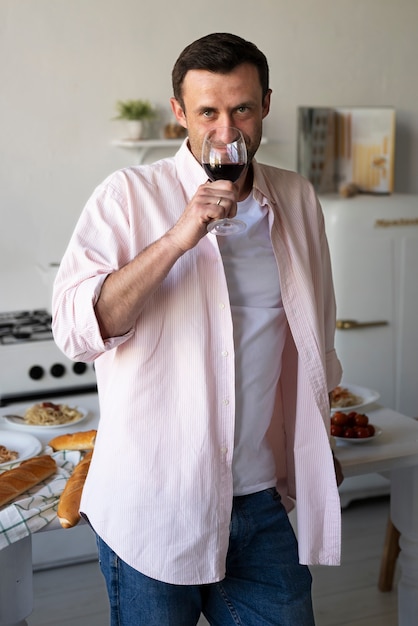 Father drinking wine in kitchen