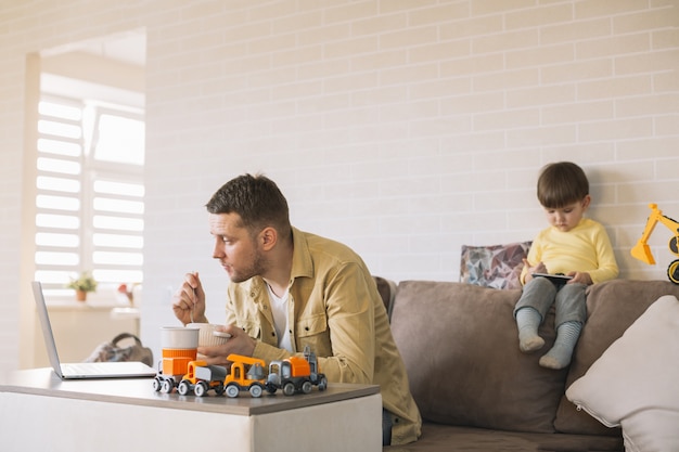 Free photo father eating and working from home