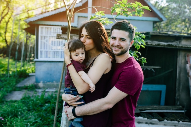 Father embracing his wife and having a baby in his arms