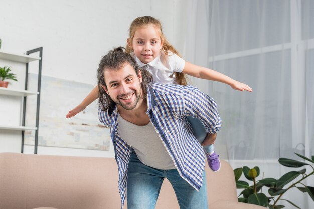 Father giving a piggy back ride to his daughter