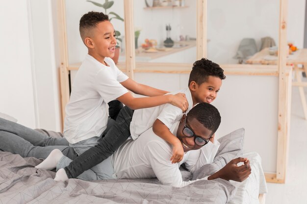 Father having fun with his sons in bed