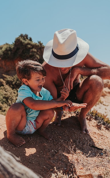 Father and his son happily playing on the sandy beach