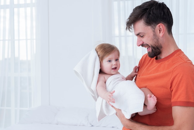 Free photo father holding baby in towel