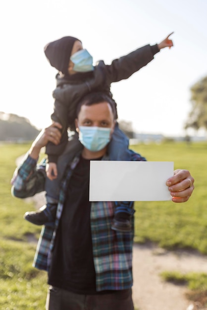 Father holding a blank paper and holding his son