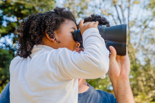Father holding girl with binoculars