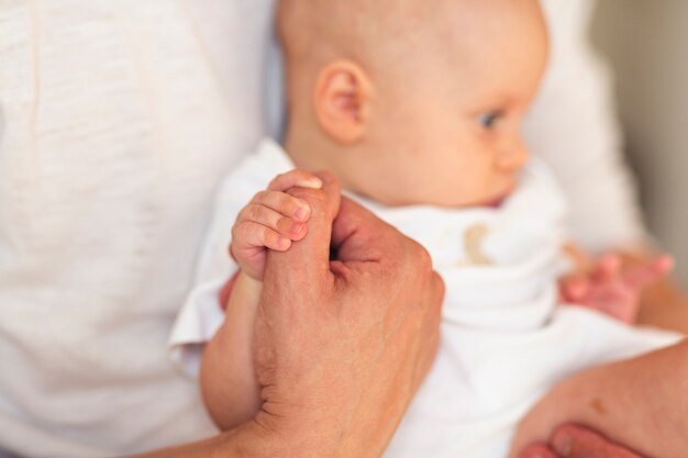 Father holding hands with baby