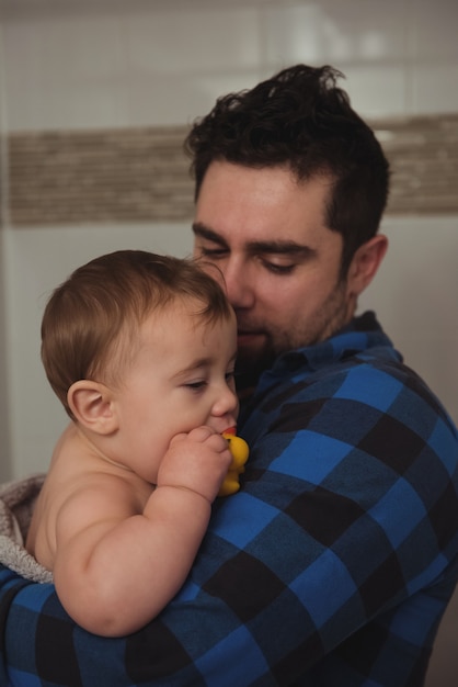 Foto gratuita padre che tiene il suo bambino in bagno